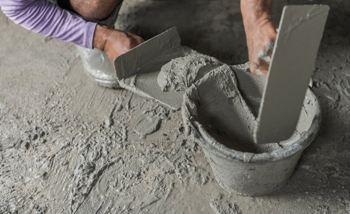 Mason preparing material by hand on site