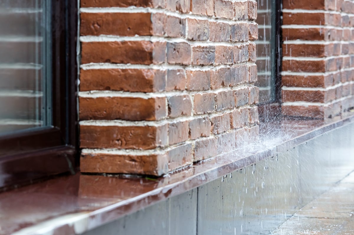 Heavy rain falling against exposed brick masonry
